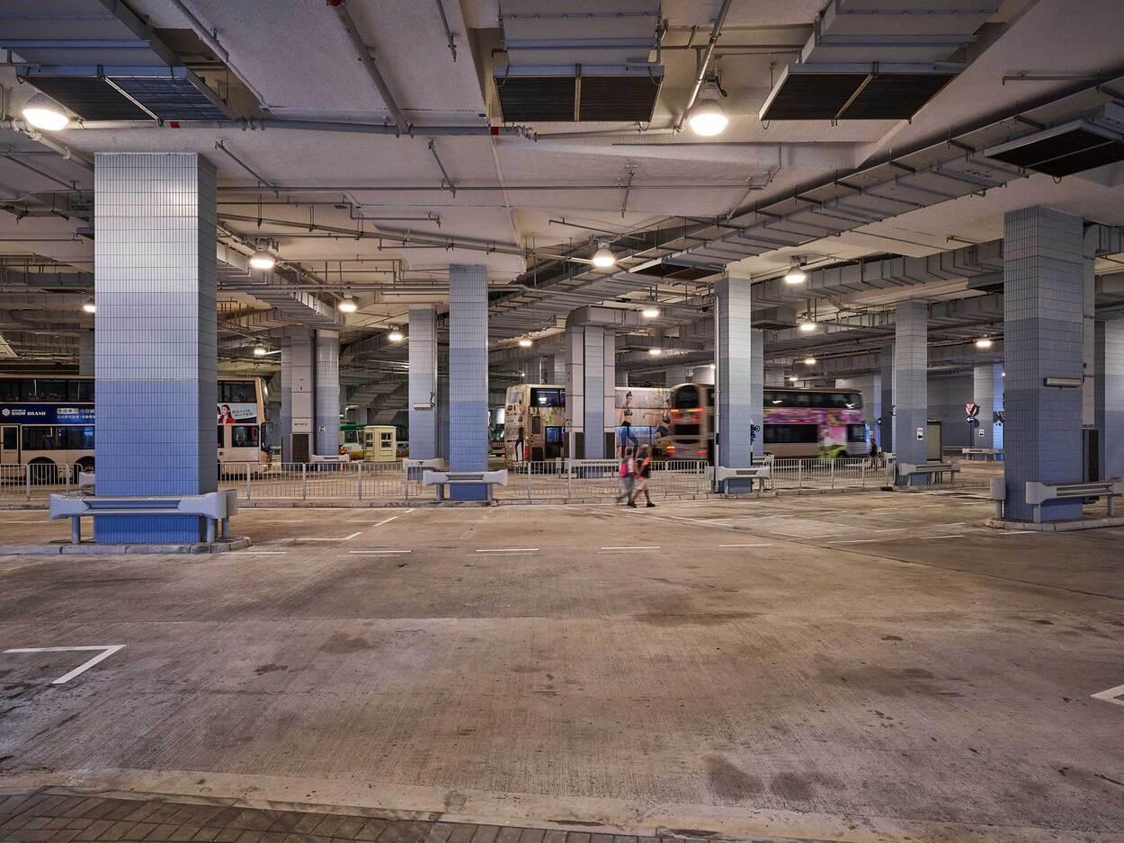 Large empty underground parking garage with concrete pillars and overhead lighting