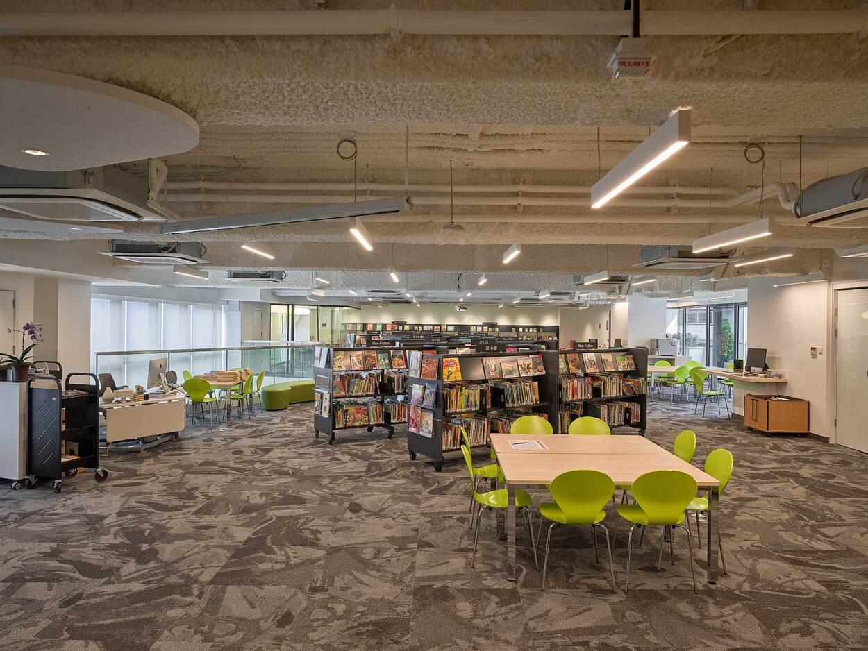 Modern library interior with bookshelves, tables and bright seating area