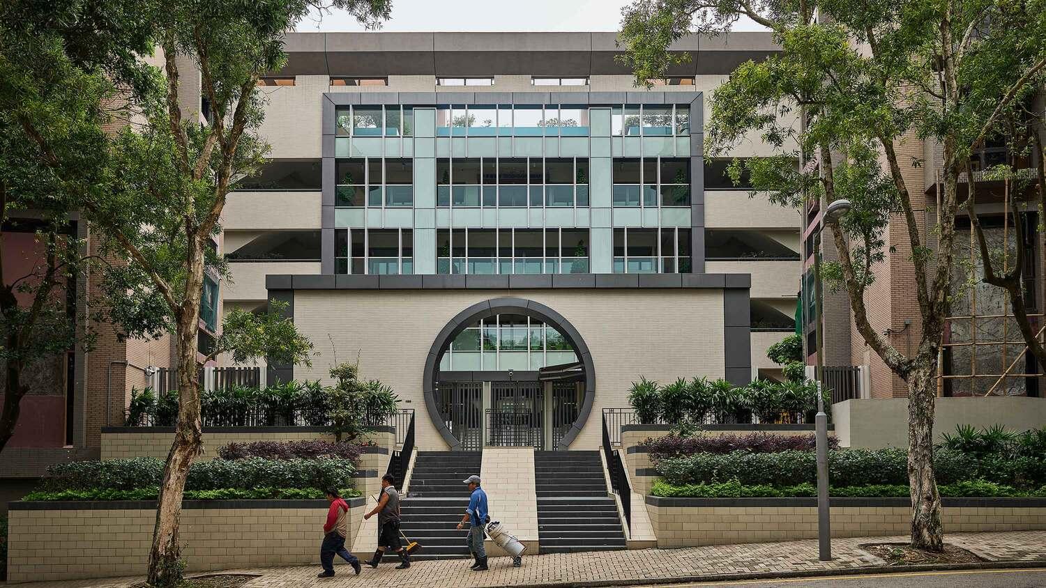 Front view of modern campus building with trees and wide entrance