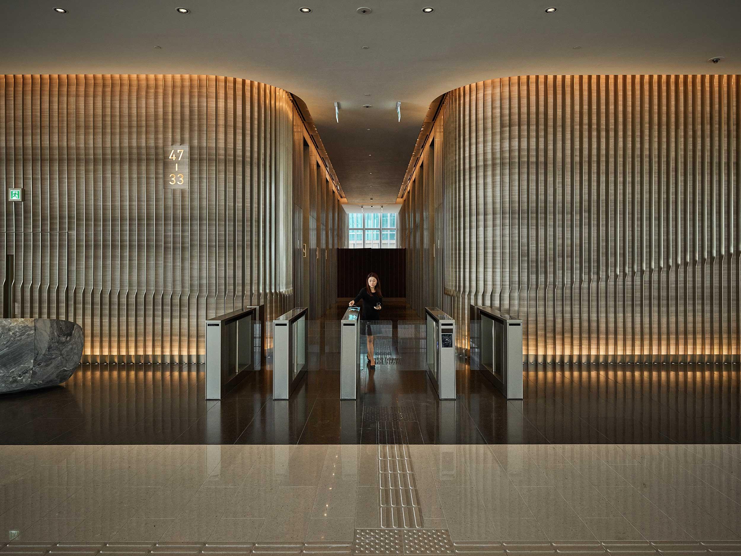 Contemporary office lobby entrance with illuminated ceiling and turnstiles