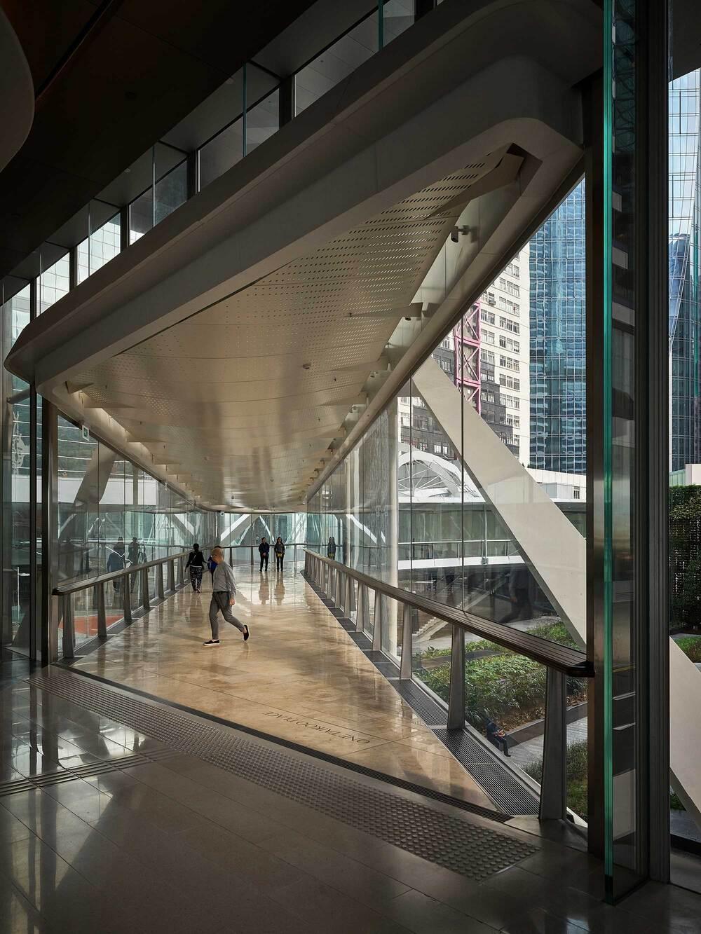 Interior of office atrium with glass walls, walkway and natural light