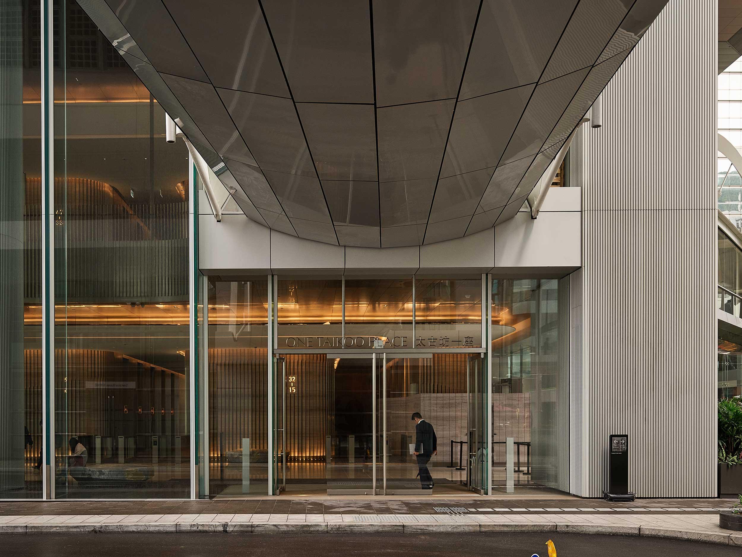 Contemporary office building entrance with large glass facade and canopy roof