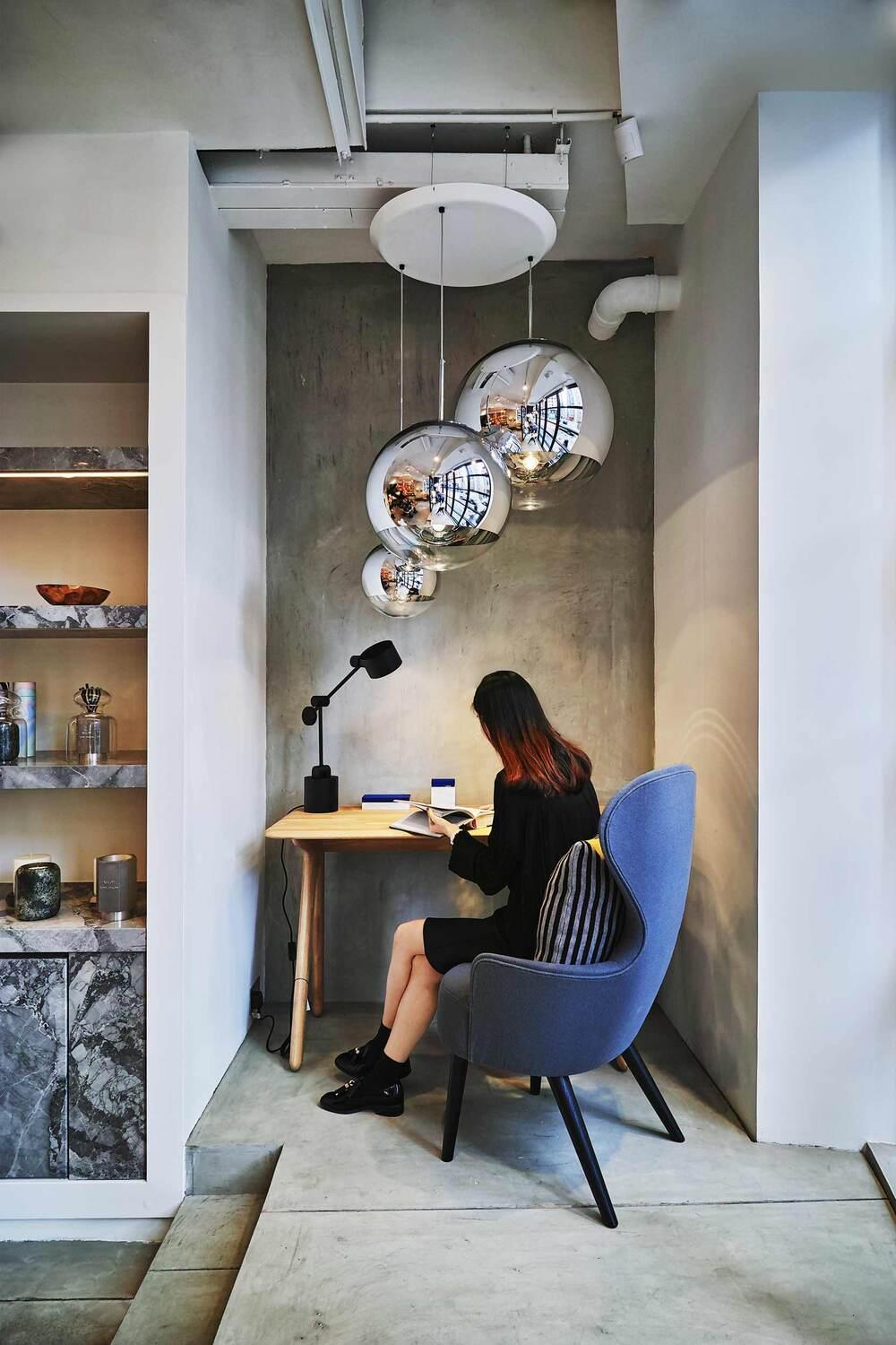 Woman sitting in a modern cafe interior in Hong Kong with designer lighting and stylish decor