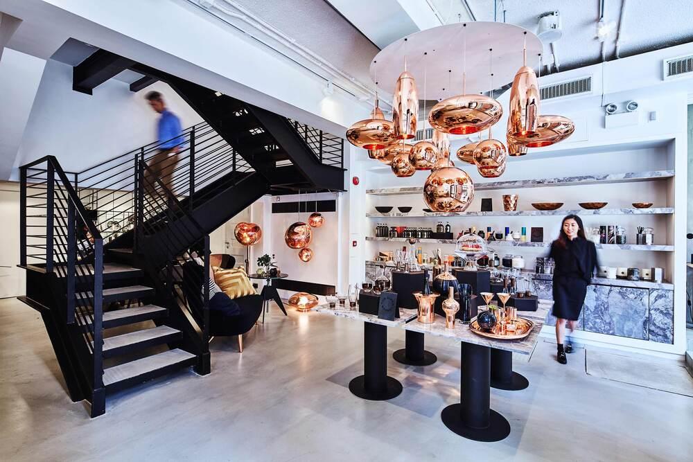 Interior view of Tom Dixon Hong Kong store with copper pendant lights, spiral staircase and modern furniture
