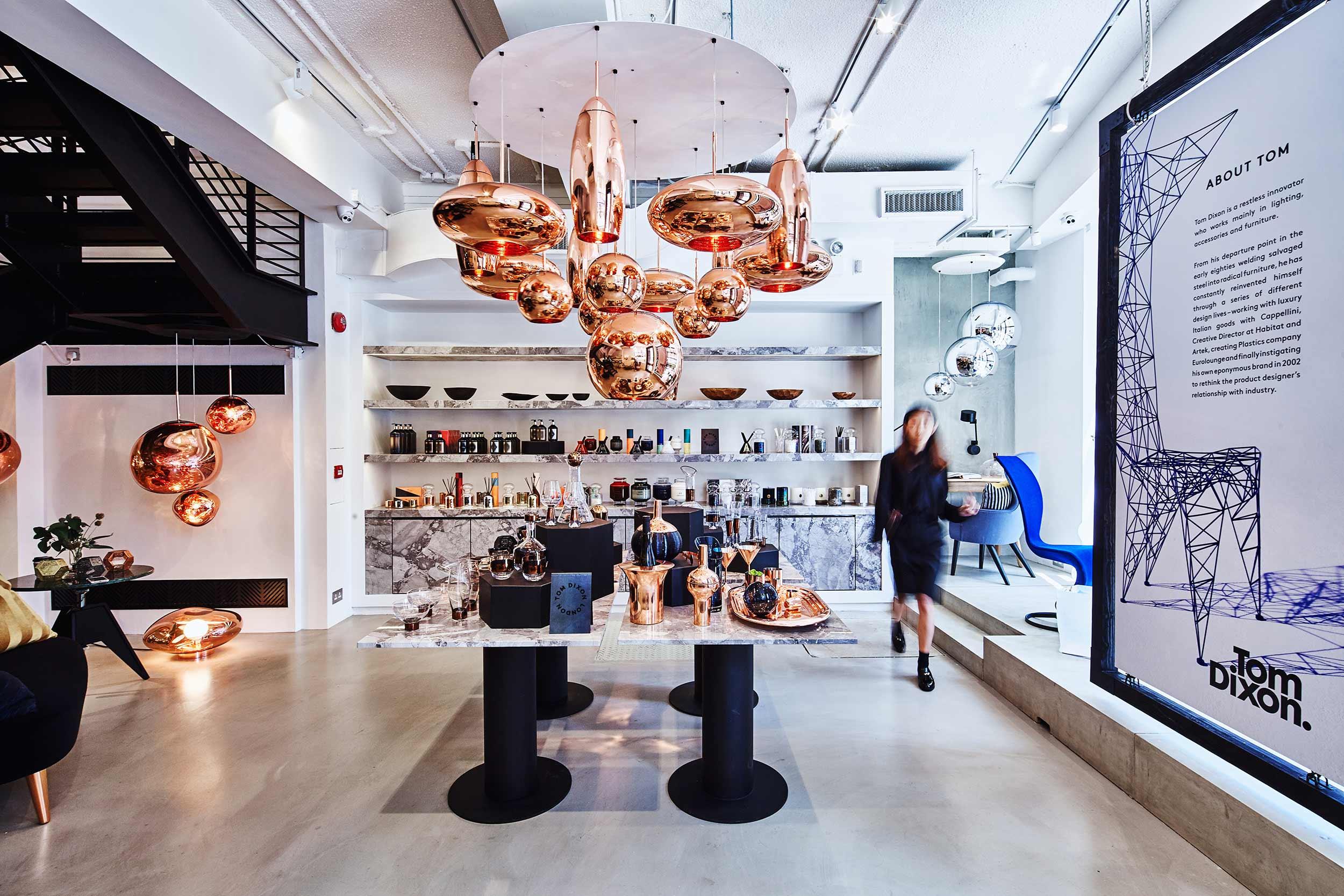 Interior view of Tom Dixon showroom in Hong Kong with copper pendant lights and modern furniture display