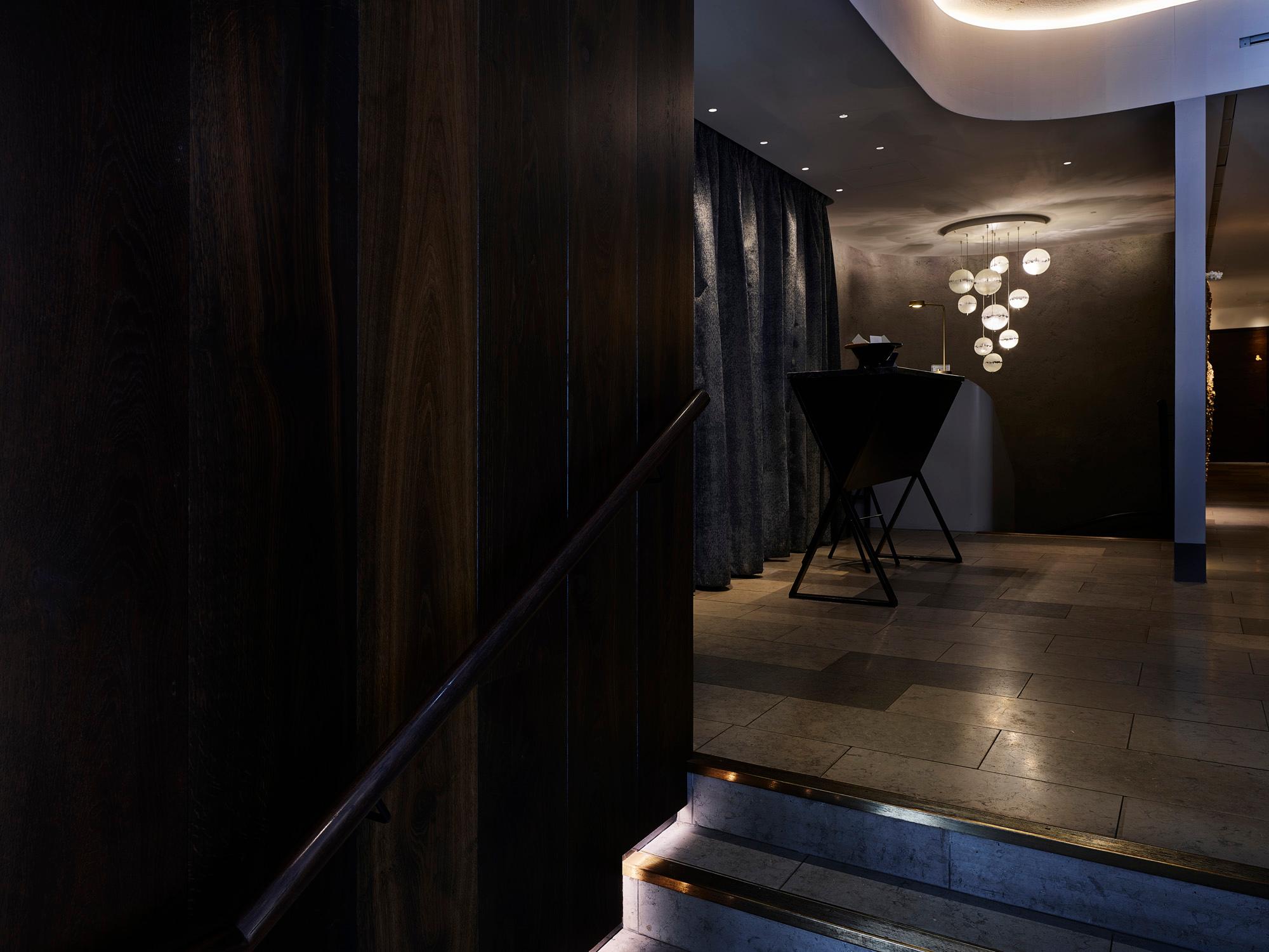 Entrance area with Acosorb acoustic ceiling and warm ambient lighting in a hotel